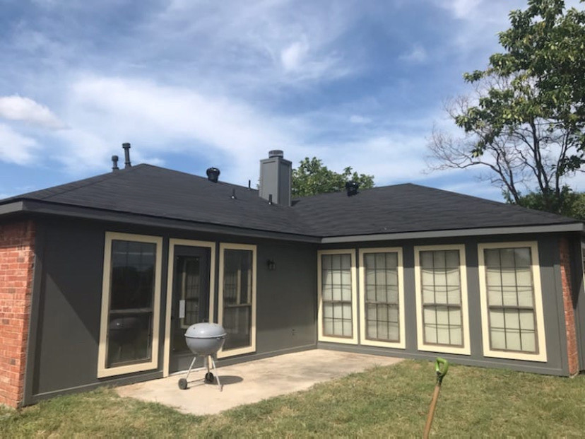After: completely transformed exterior — new roof, siding, and paint