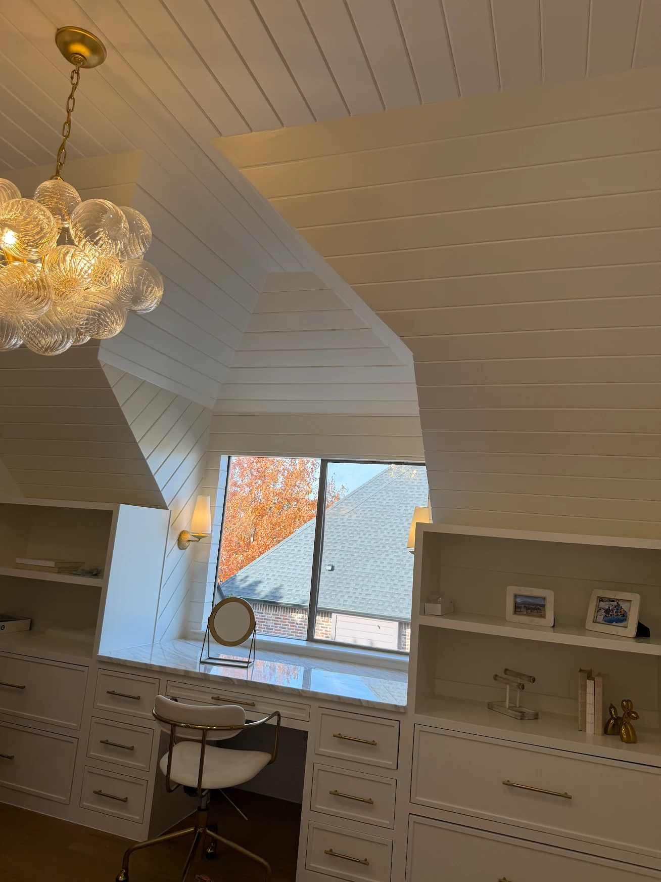Built-in white vanity desk with shiplap vaulted ceiling