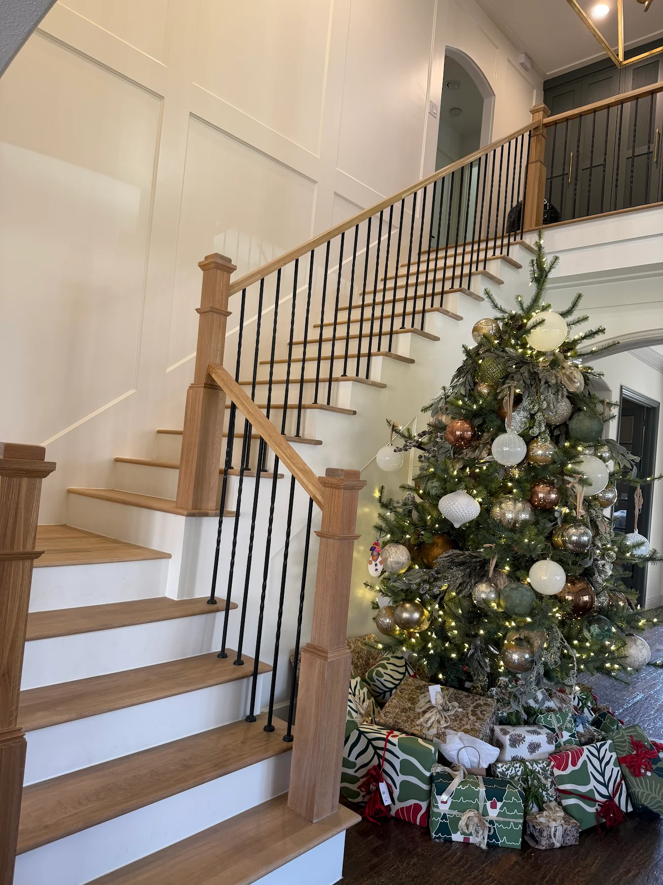 Grand staircase renovation with oak treads and iron balusters